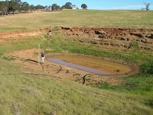  Farmer with a water depth gauge standing in a dry dam