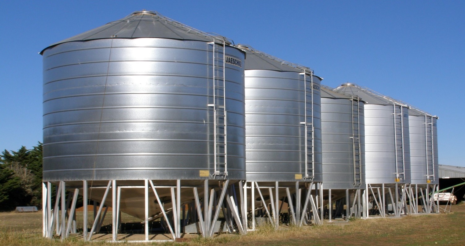 An image showing a row of grain silos on a farm.