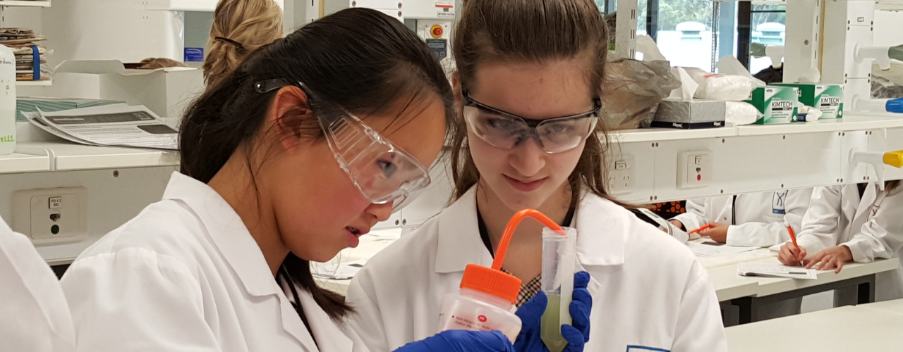 Image shows two students working with samples in a laboratory