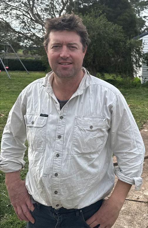 James standing with hands on hips, smiling.