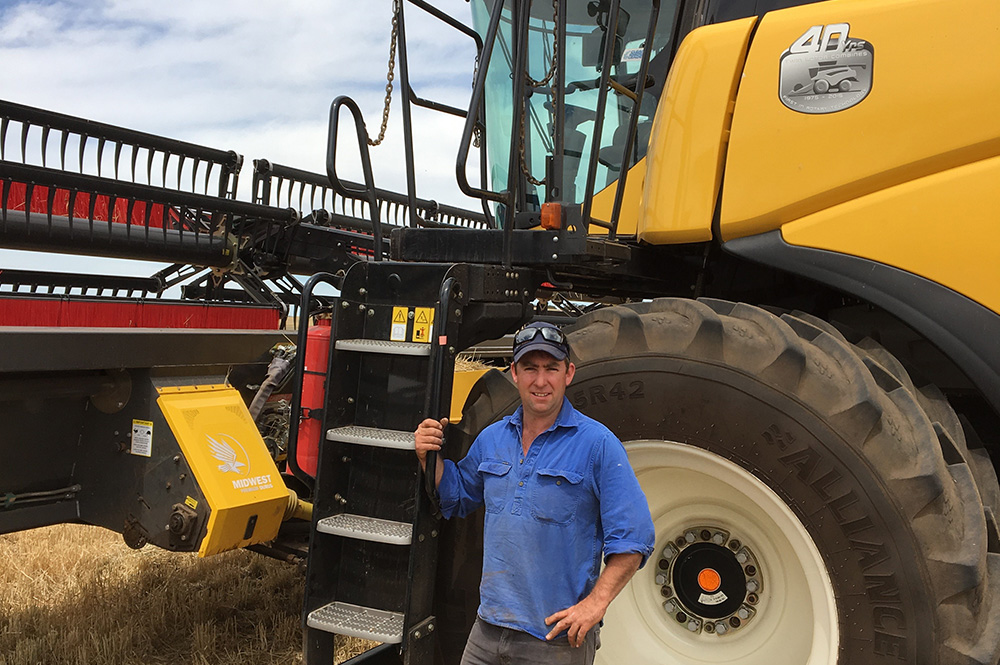 Farmer standing in front of cropping vehicle in wheat paddock