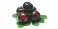 Small pile of dark purple plums with green leaves