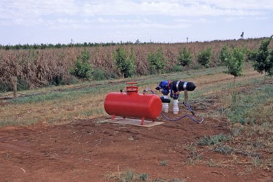 Image of a red pressure tank installed in a field.