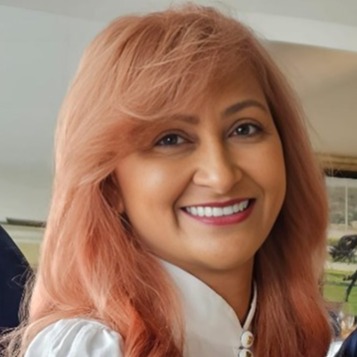 A woman with rose gold hair smiling