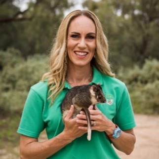 A woman holding a possum