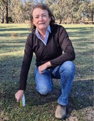 Lisa Warn crouching in a paddock