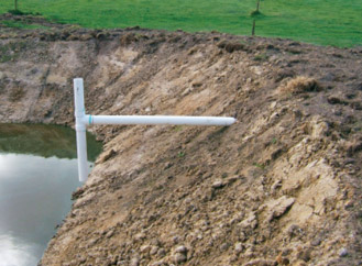 Figure 2. is a photo showing what a T-piece looks like.  A T-piece has a vertical section of pipe in the solids pond with a t-piece junction down the pipe which then travels through the dam wall into the second pond. 