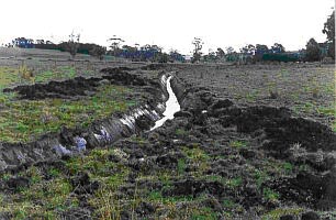 Figure 1 Open drain half-filled with water snaking through a paddock