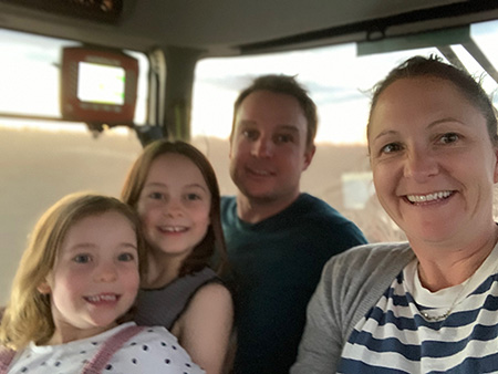McClelland parents and children in the cab of a tractor.