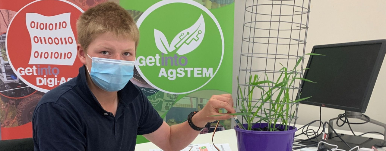 Image shows a student wearing a face mask and working in a laboratory