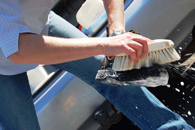 close up of vigorous brushing a working boot with soapy water