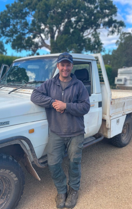 Farmer leaning on ute on a farm