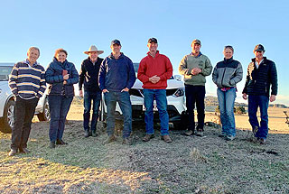 8 group members posing for a photo on a farm in New England