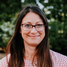 A woman wearing glasses smiling