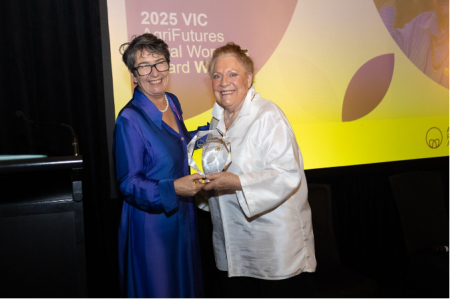 Two women holding an award