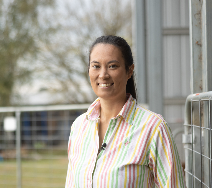 Amy Cosby standing next to a chicken coop gate. 