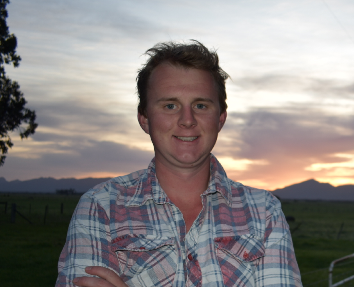 Charlie Barnes standing with a sunset in the background.