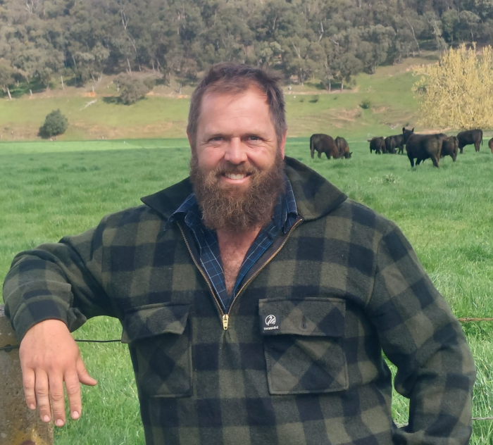 Thomas Giltrap headshot on a field with cows in the background.