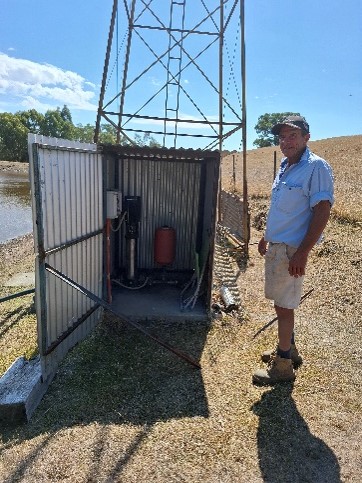 Farner standing next to electric pump on a farm
